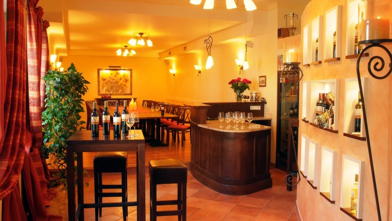 An elegant tasting room with wine bottles, glasses and stylish lighting.