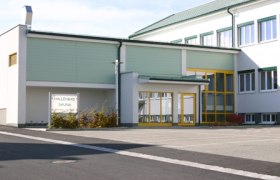 Exterior view of the Dobersberg indoor pool with yellow doors and windows.