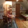 Cozy vacation apartment with wooden furniture, two beds, dining table and skylight.