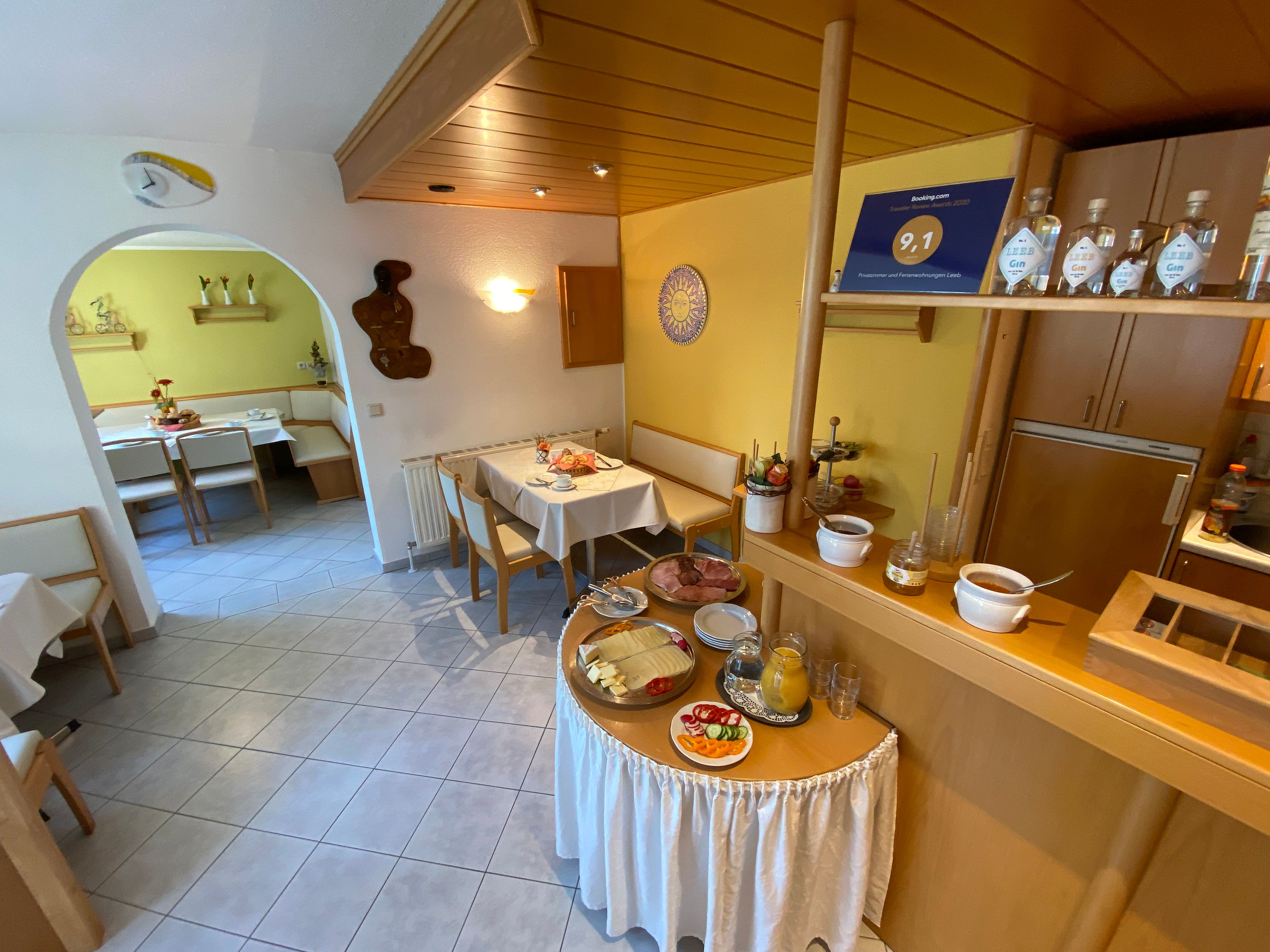 Breakfast room with laid tables and breakfast buffet.