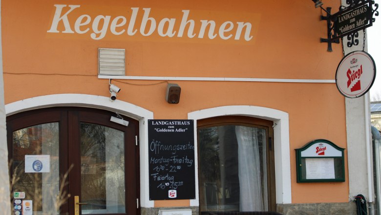 Entrance to a country inn with the inscription 'Kegelbahnen' and a Stiegl beer sign.
