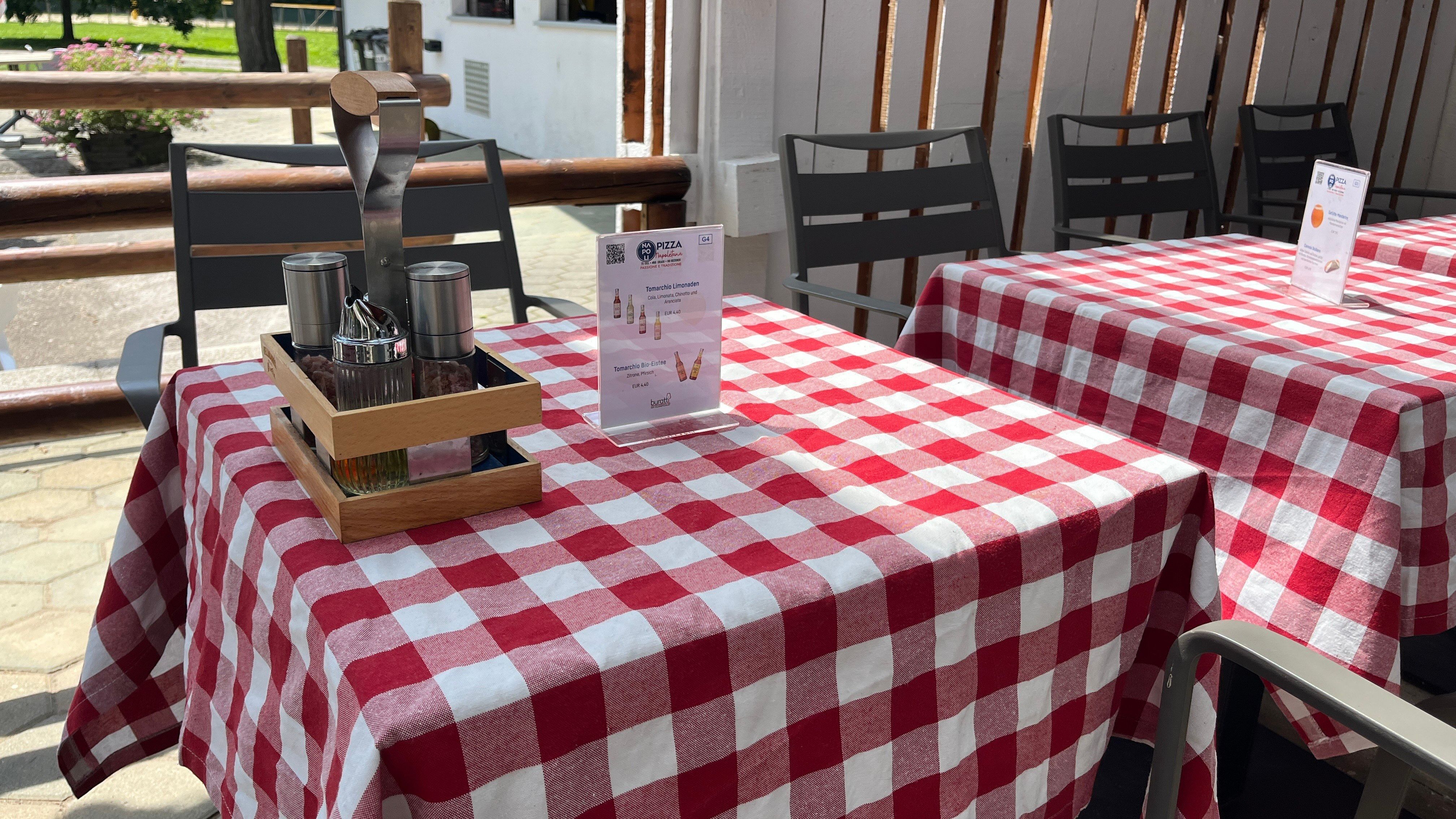 Table setting with red tablecloth and food recommendation.