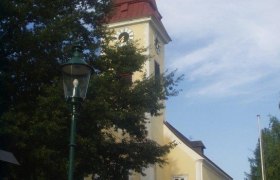 Exterior view of Sulz parish church with tower and clock.
