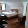 Cozy bedroom with double bed, wooden floor, carpet and antique furniture.