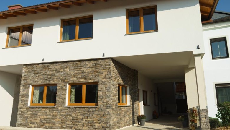 Modern house fa&ccedil;ade with white plaster and natural stone cladding.