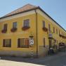 Yellow building with the inscription 'Gasthof Speneder', decorated with flowers.