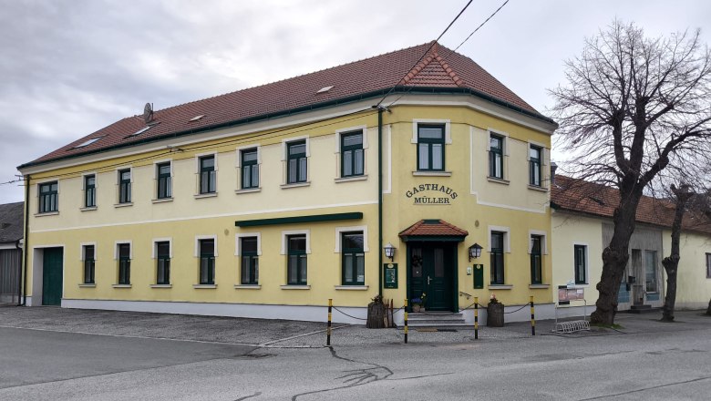 Yellow two-story building with the inscription 'Gasthaus Müller'.
