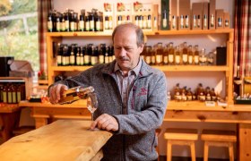 A man pours schnapps into a glass in a tasting room.