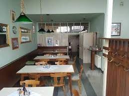 Interior viefurniture and green lamps.w of a small, cozy restaurant with wooden.