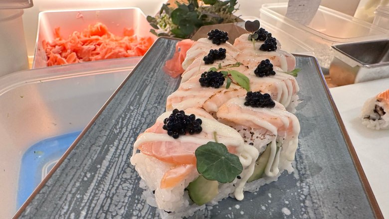 Sushi rolls with salmon and caviar on a plate.