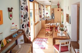 Cozy vacation apartment with wooden furniture, dining table and decorative curtains.