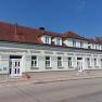 A two-storey building with a red tiled roof and white window frames, built in 1922, in sunny weather.