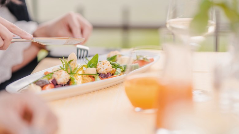 A decorated plate with an appetizer and apricot juice in the background