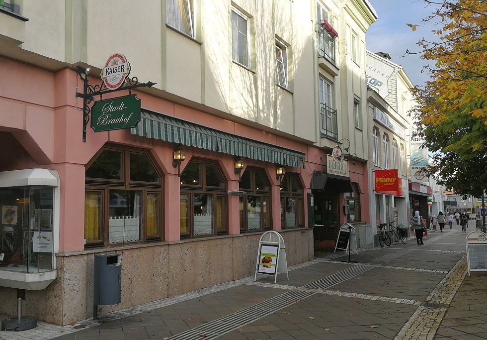 Street scene with the Stadtbrauhof Amstetten and surrounding stores.