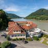 Hotel ResidenzWachau on the banks of the river with surrounding hills.