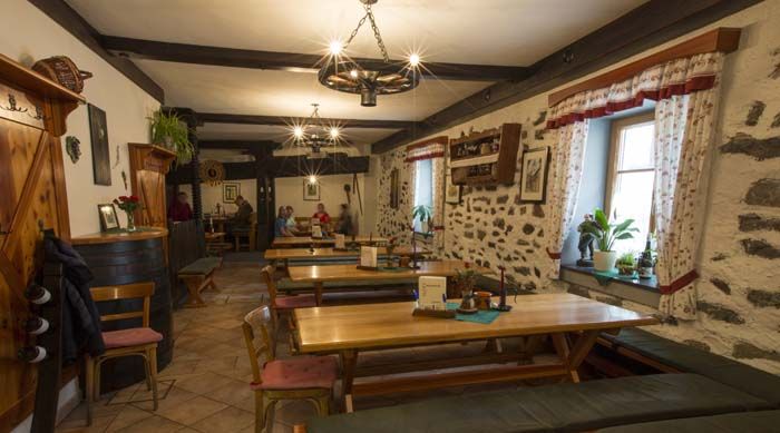 Cozy dining room with wooden tables and stone walls.