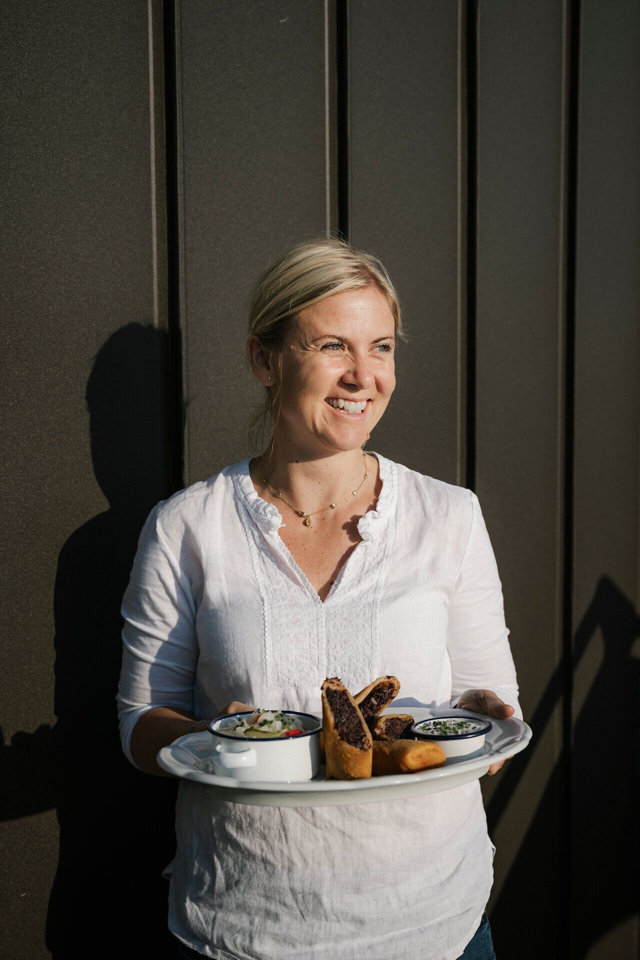 An employee at the Fischerhütte on Schneeberg with a tray full of food