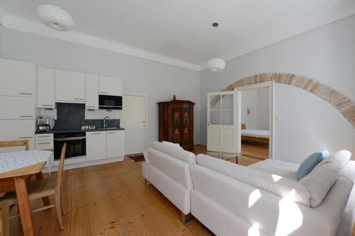 Bright living room with kitchen, sofa and dining table.