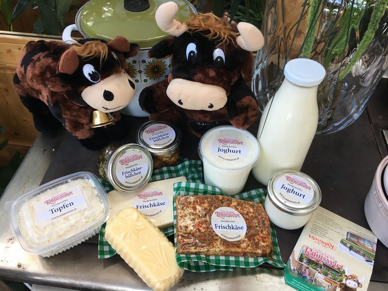 Various dairy products with two plush cows on a table.