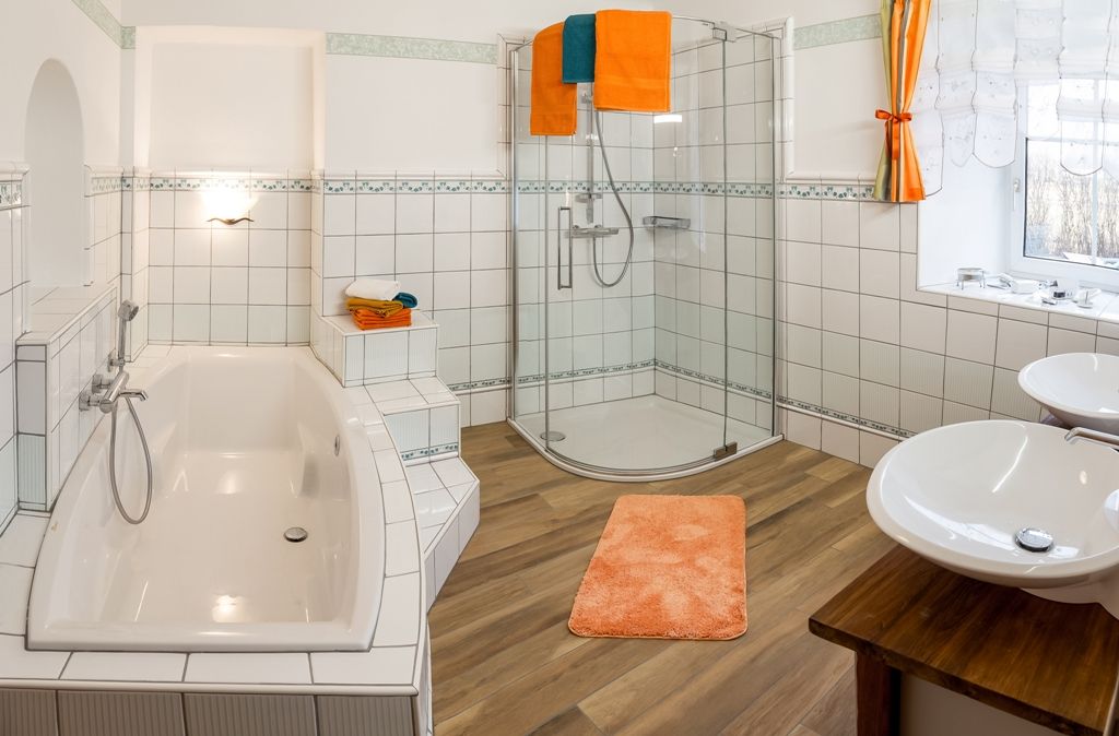 Modern bathroom with bathtub, shower and double washbasin.