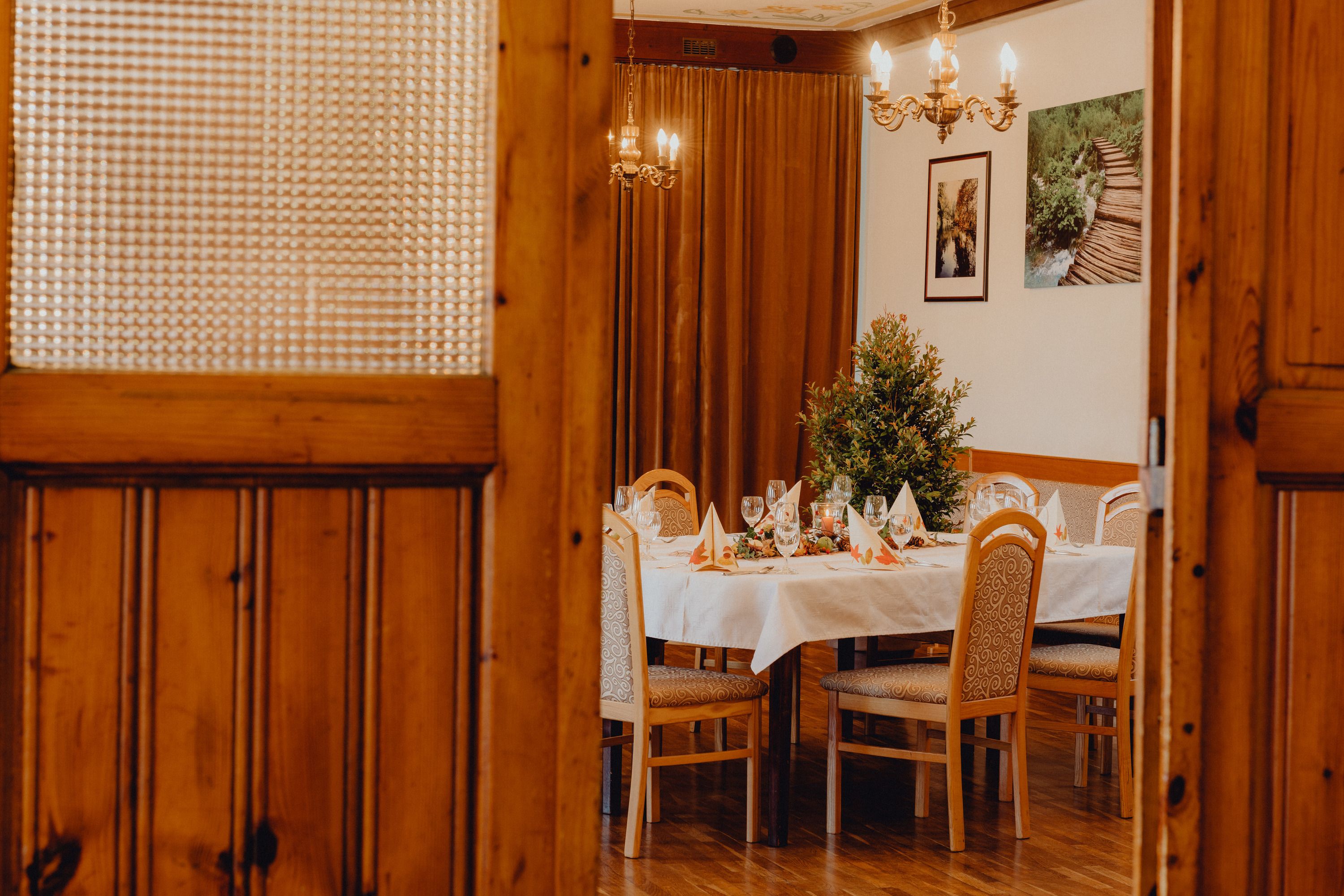 A festively laid table in a room with wooden doors and chandeliers.