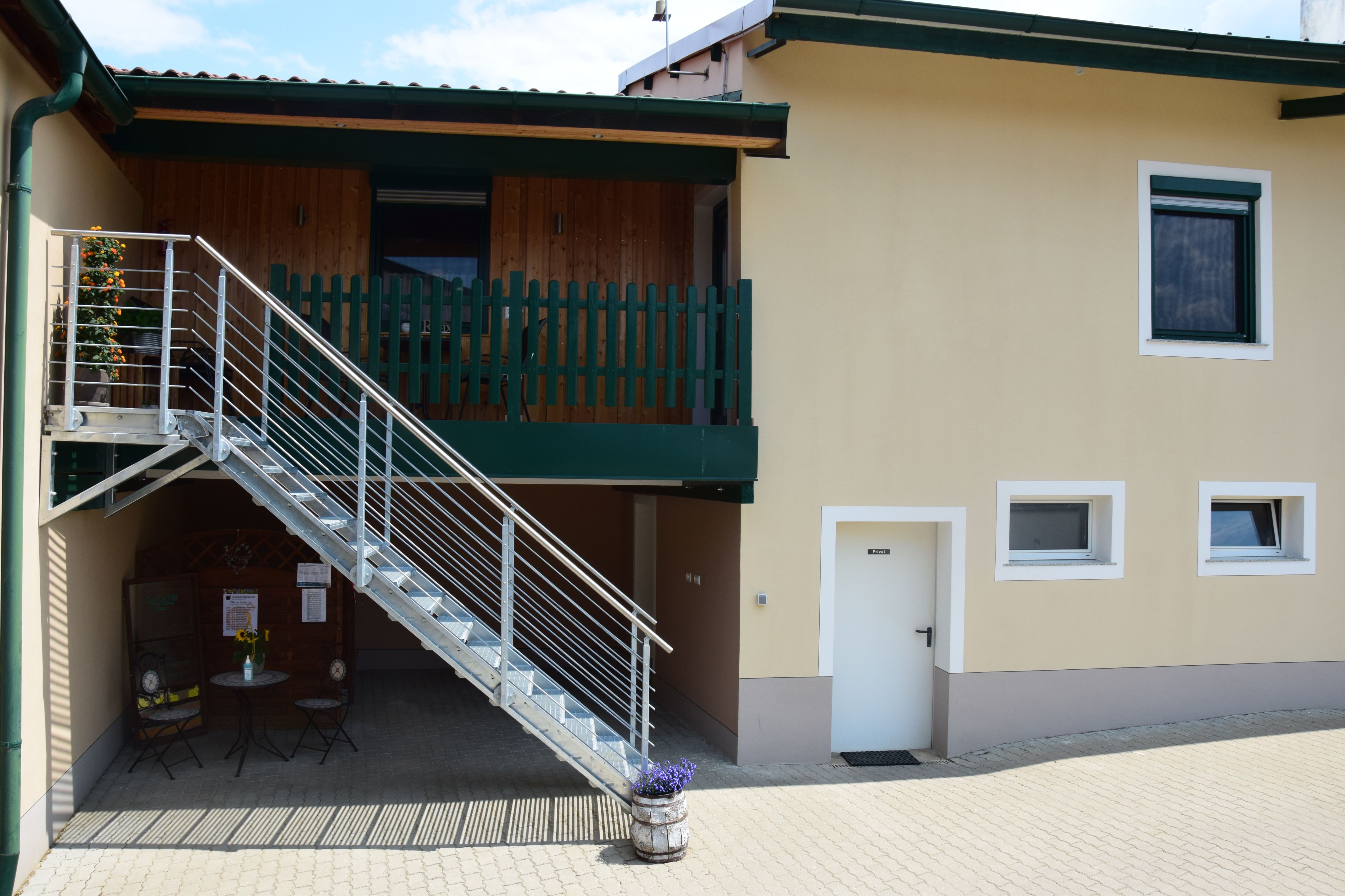 Exterior view of a building with stairs and balcony.