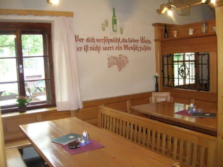 Cozy wine bar with wooden furniture and wall decorations.
