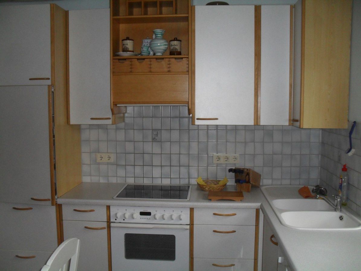 Kitchenette with stove, sink and cupboards in a vacation apartment.