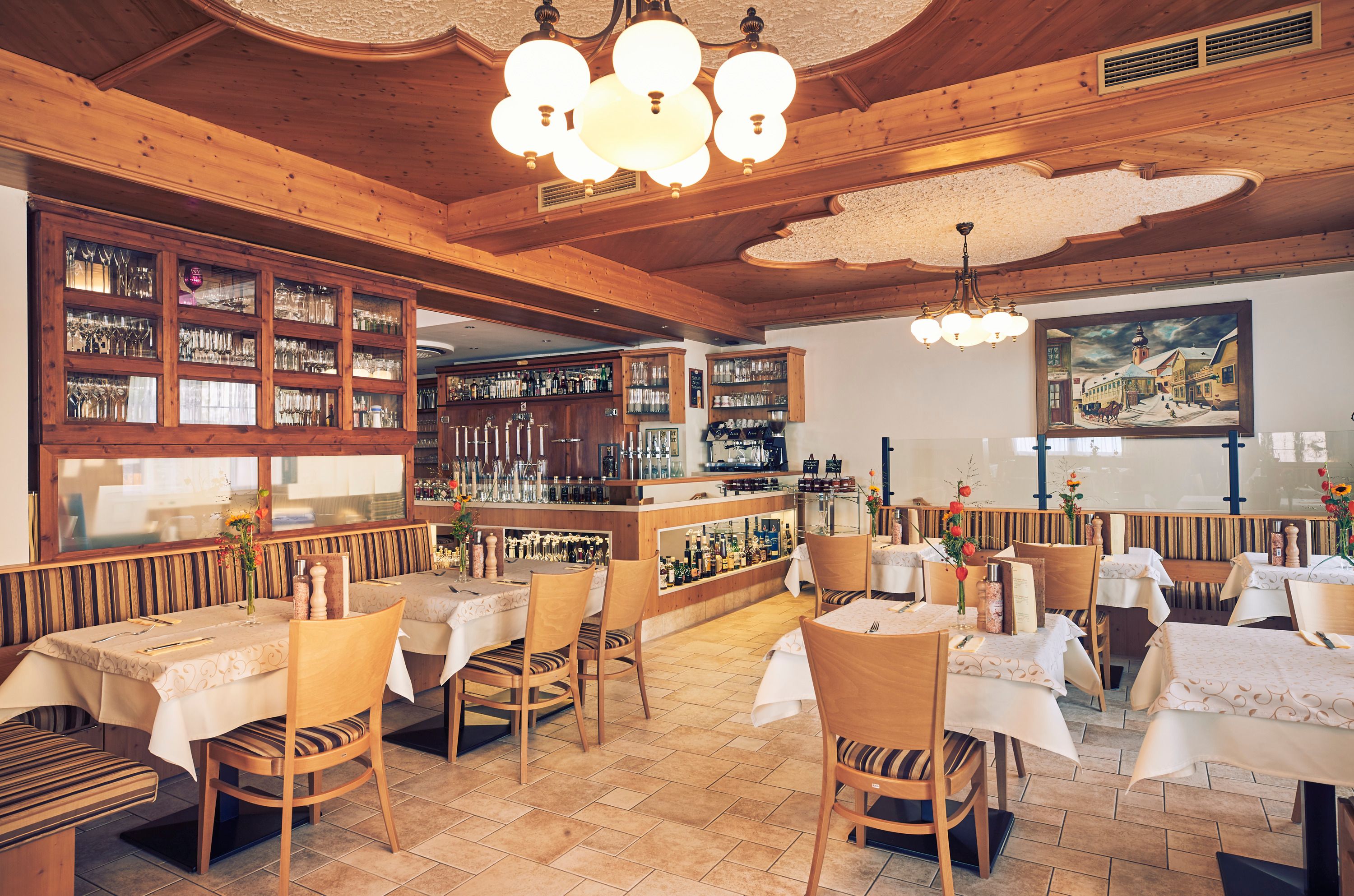 Interior view of a cozy restaurant with wooden furniture and decorative lights.