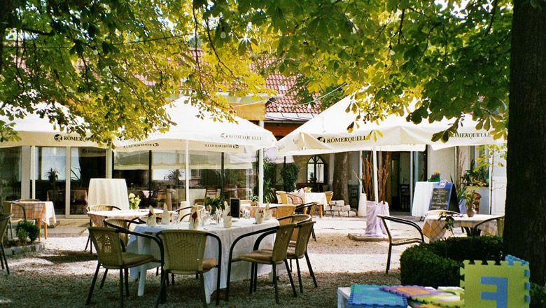 A cozy guest garden with tables and chairs under large parasols.