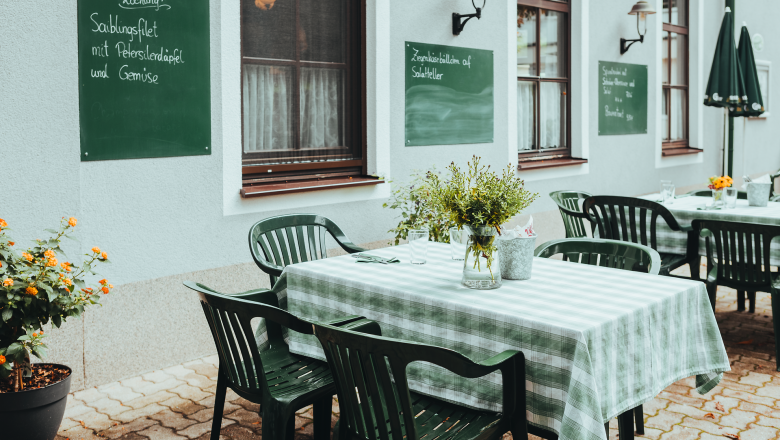 In the inviting guest garden of Gasthof Ebner, green tables and chairs invite you to linger. The fresh air and flowering plants create a harmonious atmosphere that invites you to enjoy regional delicacies.