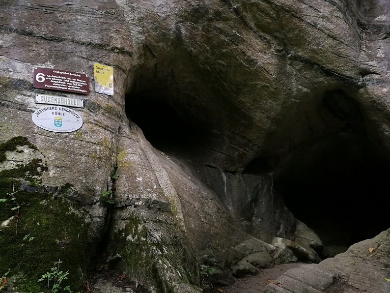 Entrance to the Gudenus Cave with signs on the rock face.