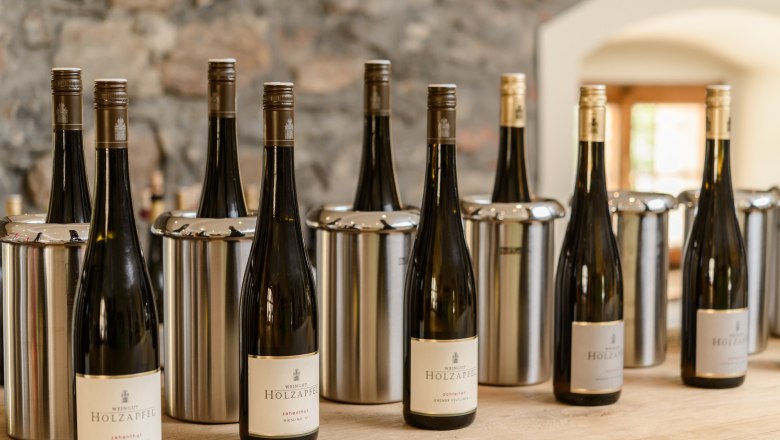 Wine bottles from the Holzapfel winery on a table.
