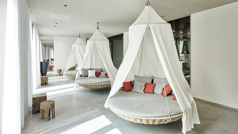 Relaxation area with hanging armchairs and cushions in the spa of the Hotel Steigenberger Krems.