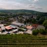 Aerial view of a winery with surrounding buildings and vineyards.