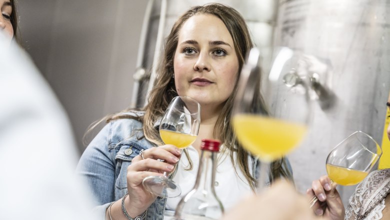 Woman at a cider tasting with glass in hand.