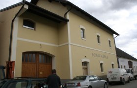 Exterior view of a yellow building with the inscription 'Schaum&uuml;hle'.