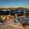 Alpengasthof Enzian in a snowy mountain landscape at sunset.