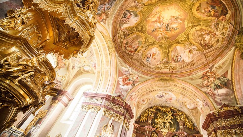 Interior view of Maria Taferl Basilica with richly decorated golden elements and frescoes on the ceiling.