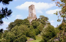 Arbesbach ruins on a wooded hill under a blue sky.