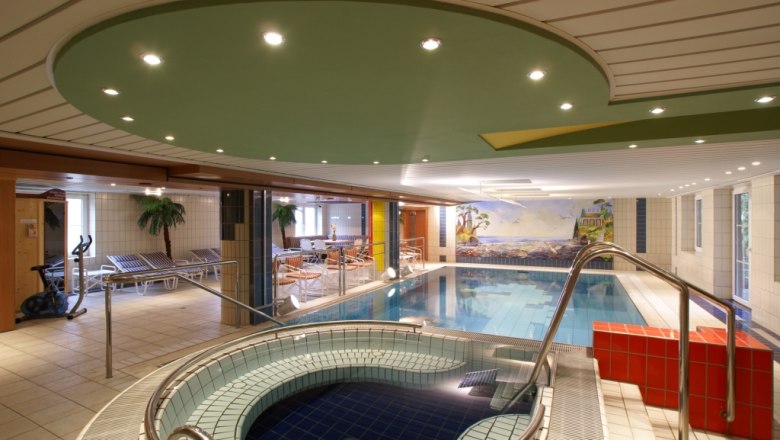 Indoor pool area with whirlpool and sun loungers at Hotel Thier.