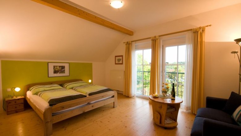 Comfortable bedroom with double bed, wooden furniture and balcony access.