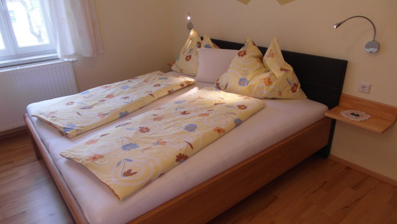 Cozy bedroom with double bed and yellow bed linen.