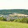 Panoramic view of Leiben with green fields and forests in the background.
