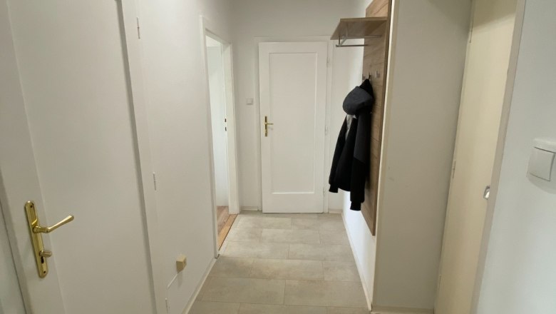 Hallway of the apartment with bright tiles and wardrobe