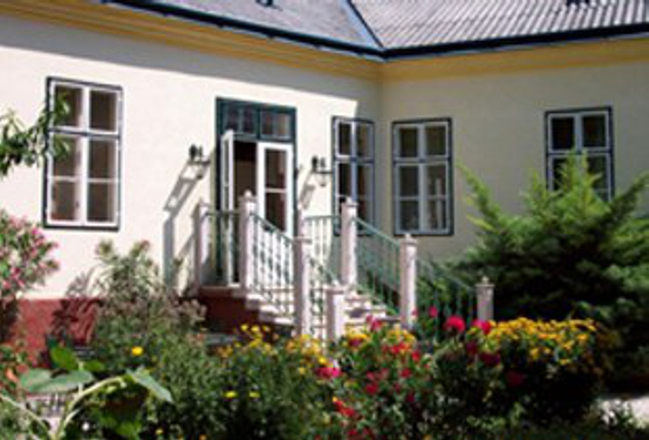 Exterior view of a house with garden and flowers.