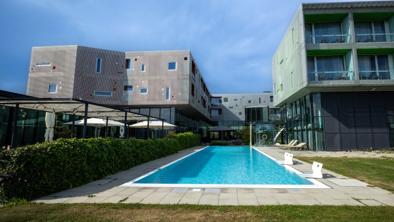 LOISIUM Langenlois, © Niederösterreich Werbung / Maximilian Pawlikowsky Modern building with pool and terrace in the foreground.