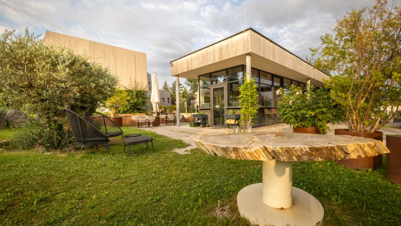 Garden area of a modern hotel with seating and plants.