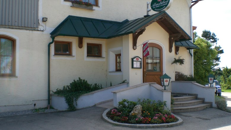 Entrance to a bed and breakfast with sign 'Almstüberl'.