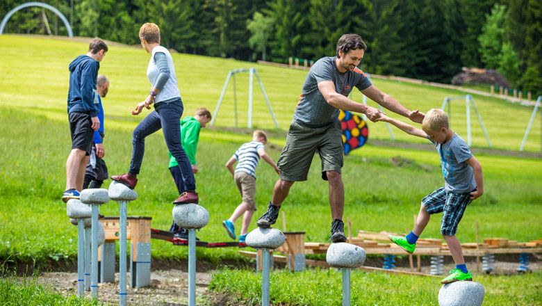 People balance on stones in the motor skills park.